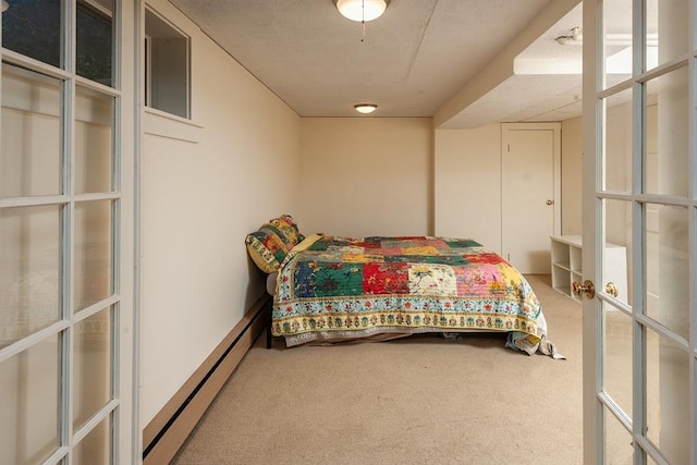 bedroom with a baseboard heating unit, carpet flooring, and french doors