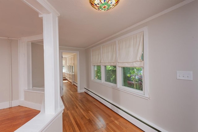 hall with light wood-style flooring, ornamental molding, baseboards, and a baseboard radiator