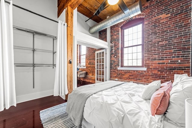 37 Millyard Unit 206, Amesbury, MA 01913 - bedroom featuring brick wall, wooden ceiling, wood finished floors, baseboards, and a closet