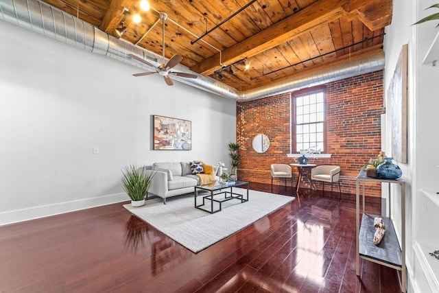 37 Millyard Unit 206, Amesbury, MA 01913 - living room featuring wooden ceiling, brick wall, hardwood / wood-style flooring, baseboards, and beamed ceiling