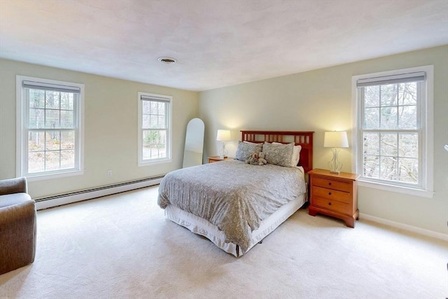 carpeted bedroom with baseboards, a baseboard heating unit, and visible vents
