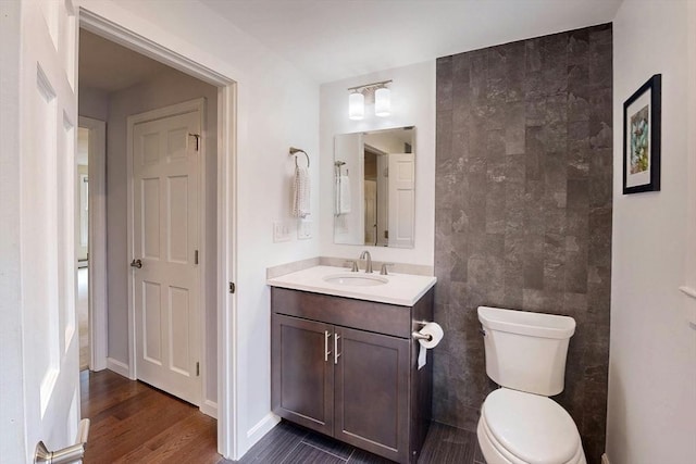 bathroom with vanity, toilet, and wood finished floors