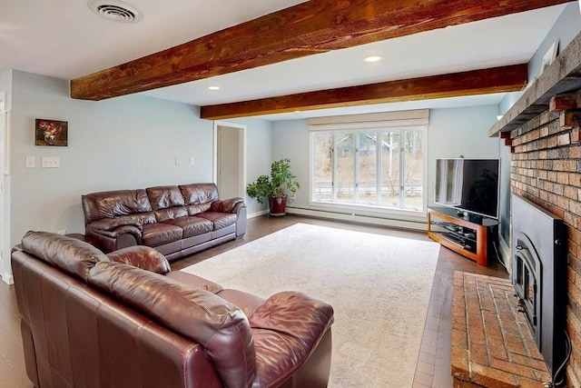 living area featuring visible vents, a brick fireplace, wood finished floors, beamed ceiling, and a baseboard heating unit