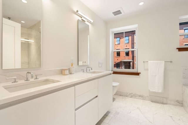 bathroom featuring vanity, a shower with door, toilet, and a wealth of natural light