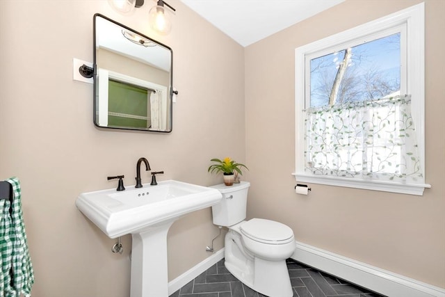 bathroom with toilet, a baseboard heating unit, tile patterned floors, and sink