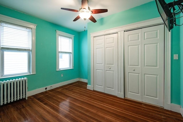 30 Partridge Ave, Somerville, MA 02145 - unfurnished bedroom with radiator, dark wood-style flooring, baseboards, a ceiling fan, and a closet