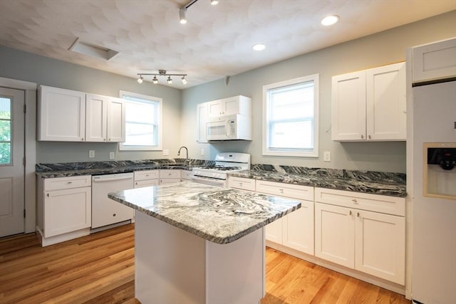 30 Partridge Ave, Somerville, MA 02145 - kitchen with white appliances, track lighting, dark stone countertops, and light wood finished floors