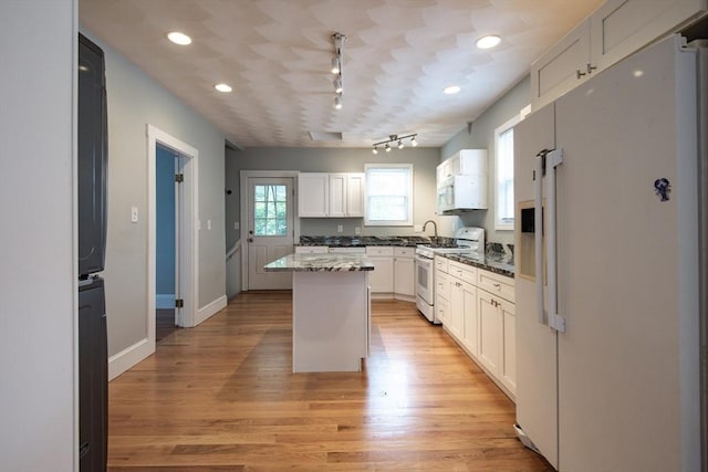 30 Partridge Ave, Somerville, MA 02145 - kitchen with white appliances, a center island, white cabinetry, track lighting, and light wood-style flooring