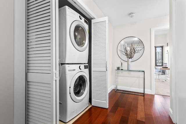 laundry area featuring dark wood-type flooring and stacked washing maching and dryer