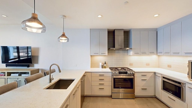 kitchen with stainless steel appliances, a sink, wall chimney exhaust hood, light wood-style flooring, and tasteful backsplash