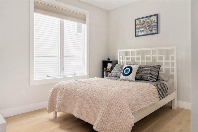 bedroom with baseboards and wood finished floors