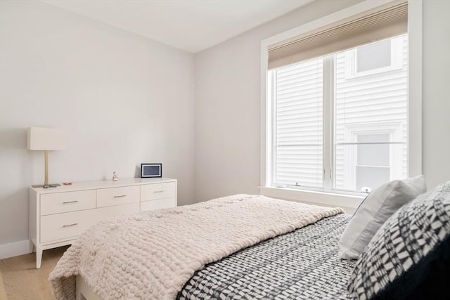 bedroom with light wood-style floors and baseboards