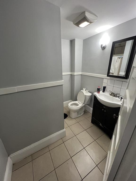 bathroom with tile patterned floors, toilet, baseboards, and vanity