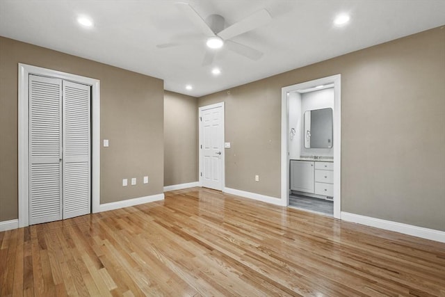 unfurnished bedroom with ceiling fan, light wood-type flooring, and connected bathroom