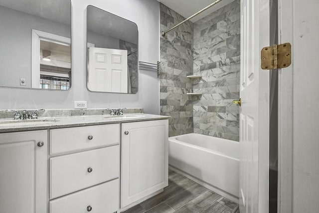 bathroom featuring hardwood / wood-style floors, vanity, and tiled shower / bath