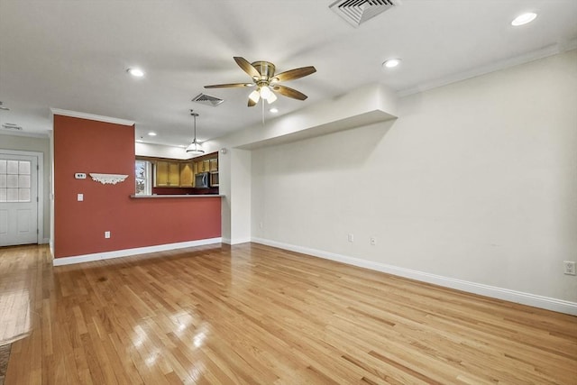 unfurnished living room featuring ceiling fan, ornamental molding, and light wood-type flooring