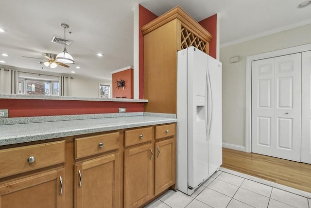 kitchen featuring ceiling fan, crown molding, light tile patterned floors, and white refrigerator with ice dispenser