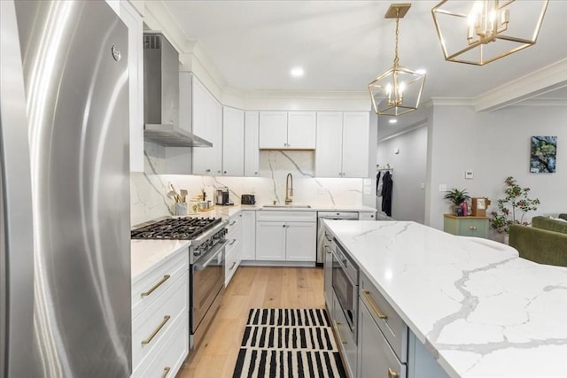 68 Evergreen Unit B, Newton, MA 02466 - kitchen featuring light wood-style floors, wall chimney exhaust hood, a chandelier, a sink, and appliances with stainless steel finishes