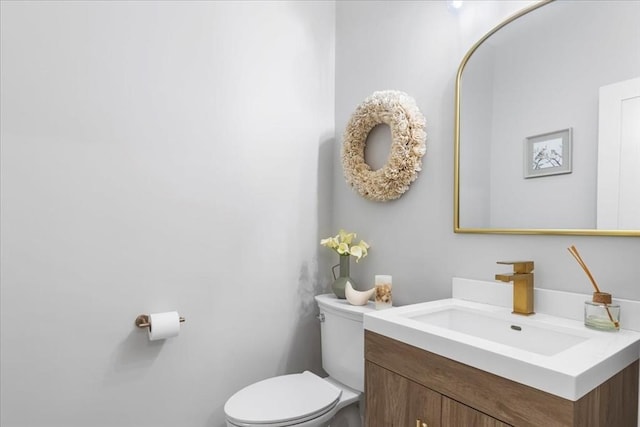 half bathroom with vanity and toilet