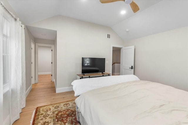 bedroom with a ceiling fan, baseboards, lofted ceiling, light wood-type flooring, and visible vents