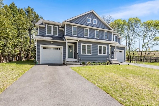 view of front of property featuring an attached garage, fence, a front yard, and aphalt driveway