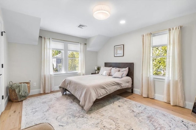 bedroom featuring baseboards, wood finished floors, and visible vents
