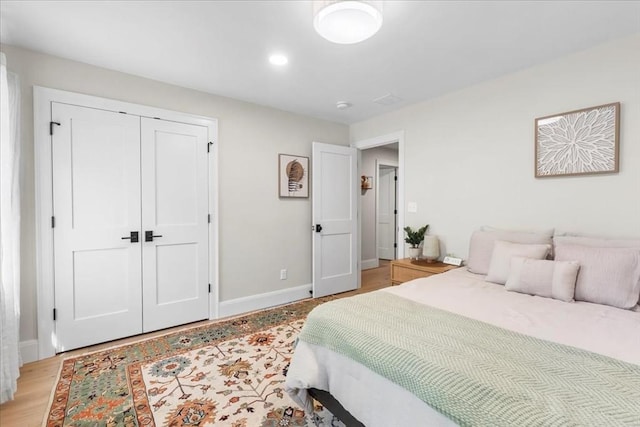 bedroom featuring baseboards, a closet, and light wood-type flooring