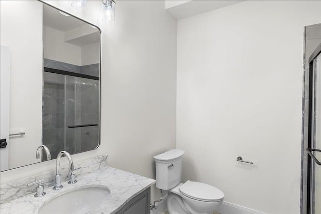 bathroom with an enclosed shower, toilet, baseboards, and vanity
