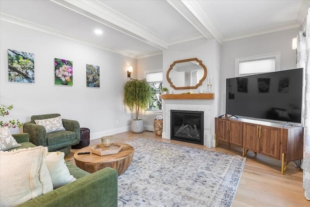 living area with a high end fireplace, crown molding, beamed ceiling, and light wood-style flooring