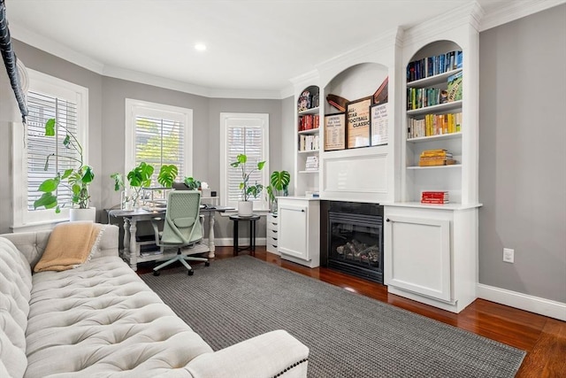 office with dark wood finished floors, ornamental molding, baseboards, built in shelves, and recessed lighting