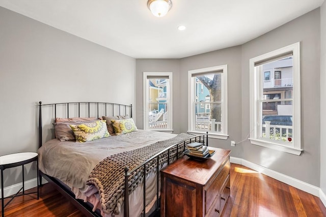 bedroom with baseboards, wood finished floors, and recessed lighting