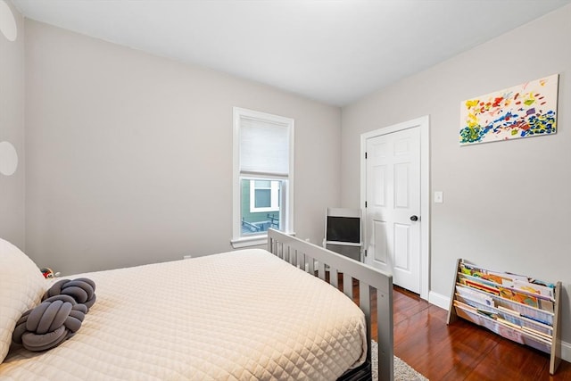 bedroom with wood finished floors and baseboards