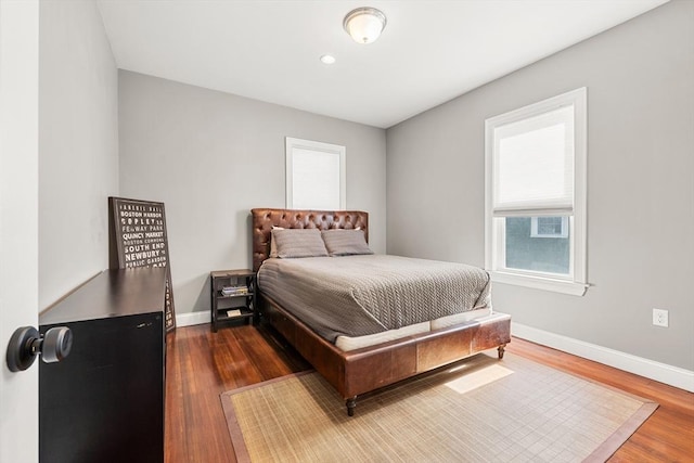 bedroom featuring dark wood finished floors and baseboards
