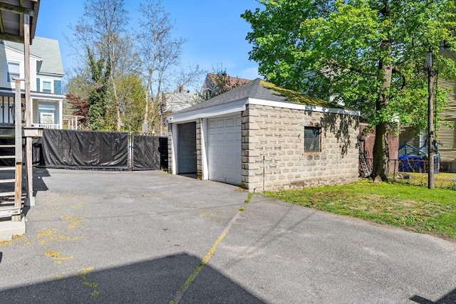 detached garage featuring fence