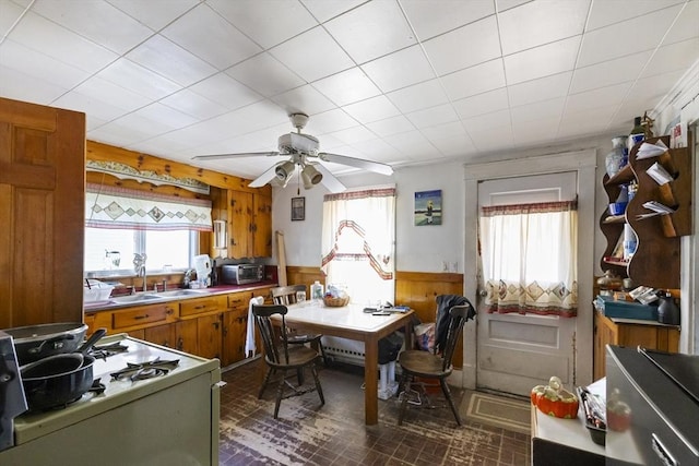 17 Westminster, Westfield, MA 01085 - kitchen featuring brown cabinetry, gas range gas stove, brick patterned flooring, a sink, and a ceiling fan
