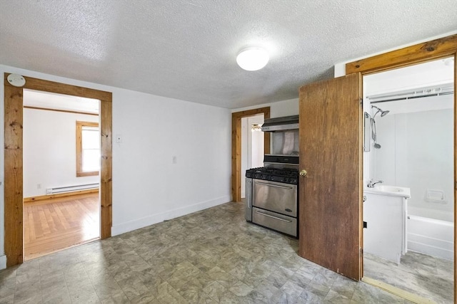 17 Westminster, Westfield, MA 01085 - kitchen featuring stainless steel range with gas stovetop, under cabinet range hood, a baseboard radiator, a textured ceiling, and tile patterned floors