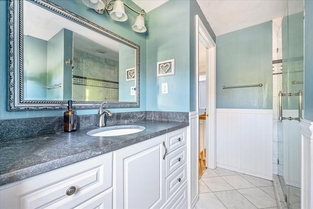 127 Main St, Norwell, MA 02061 - bathroom featuring vanity, a tile shower, wainscoting, and tile patterned flooring