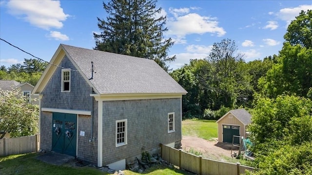 127 Main St, Norwell, MA 02061 - view of side of property with a detached garage, brick siding, and roof with shingles