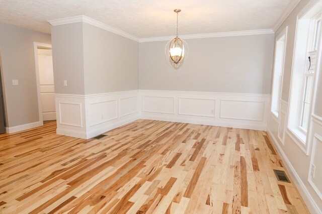 spare room with light hardwood / wood-style floors and crown molding