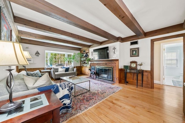 271 Haverhill St, North Reading, MA 01864 - living room with beam ceiling, a brick fireplace, hardwood / wood-style flooring, and baseboards