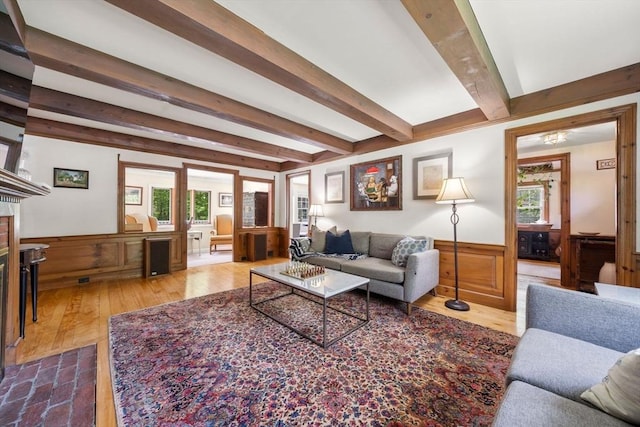 271 Haverhill St, North Reading, MA 01864 - living area with wainscoting, beamed ceiling, wood finished floors, and a brick fireplace