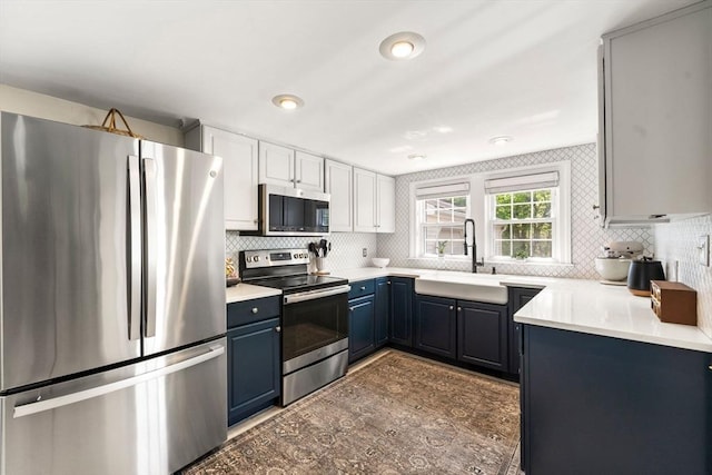 271 Haverhill St, North Reading, MA 01864 - kitchen featuring stainless steel appliances, a sink, blue cabinets, and decorative backsplash