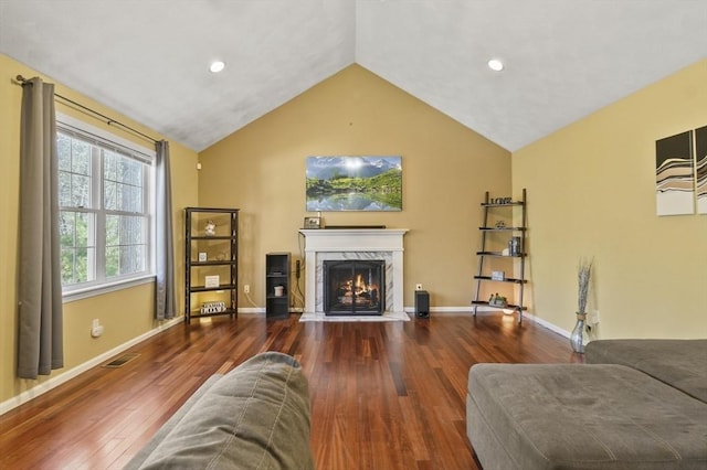 15 Whitewood Cir, Amesbury, MA 01913 - living area featuring visible vents, a premium fireplace, vaulted ceiling, and wood finished floors