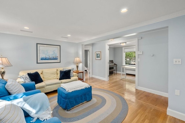 living area with radiator, light wood-style floors, baseboards, recessed lighting, and crown molding