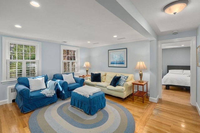 living room featuring light wood-style flooring, baseboards, and recessed lighting