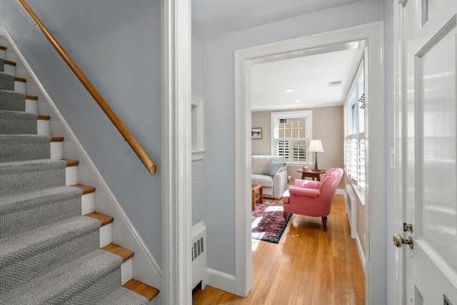 stairs with hardwood / wood-style floors and baseboards