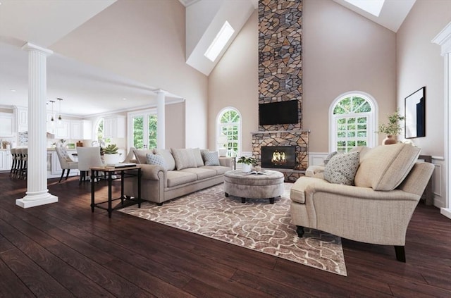 living area with dark wood-style floors, plenty of natural light, a fireplace, and decorative columns