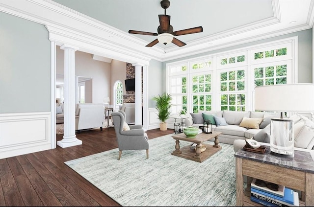 living area with a wainscoted wall, decorative columns, ceiling fan, hardwood / wood-style flooring, and crown molding