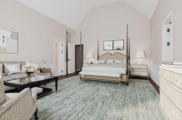 bedroom with a wainscoted wall, high vaulted ceiling, and wood finished floors