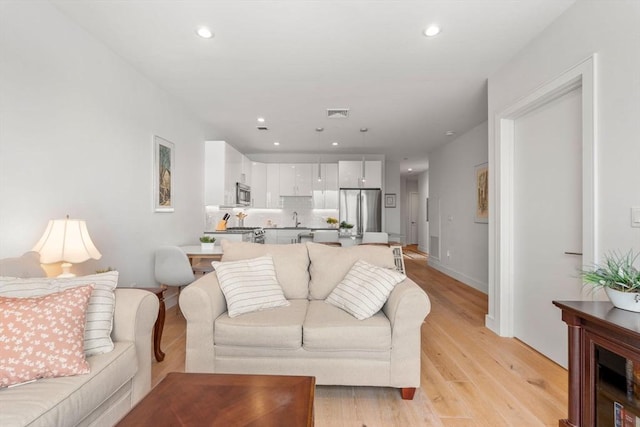 living room featuring sink and light wood-type flooring